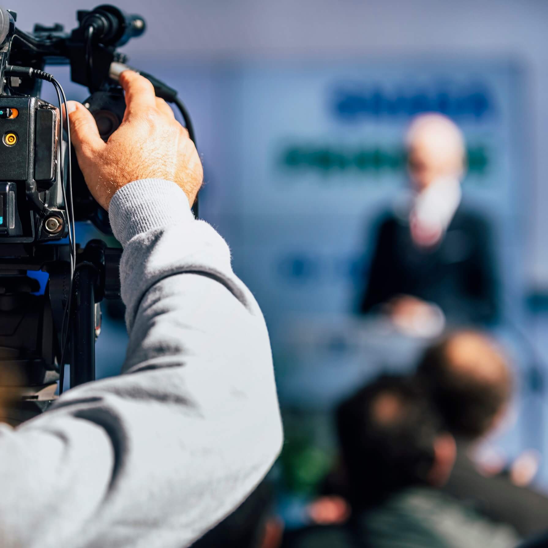 media-event-cameraman-recording-speaker-on-stage-FCWH6PL.jpg